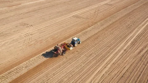 Potato harvester extracting potatoes from ground in rural field aerial view Stock Footage 313453580