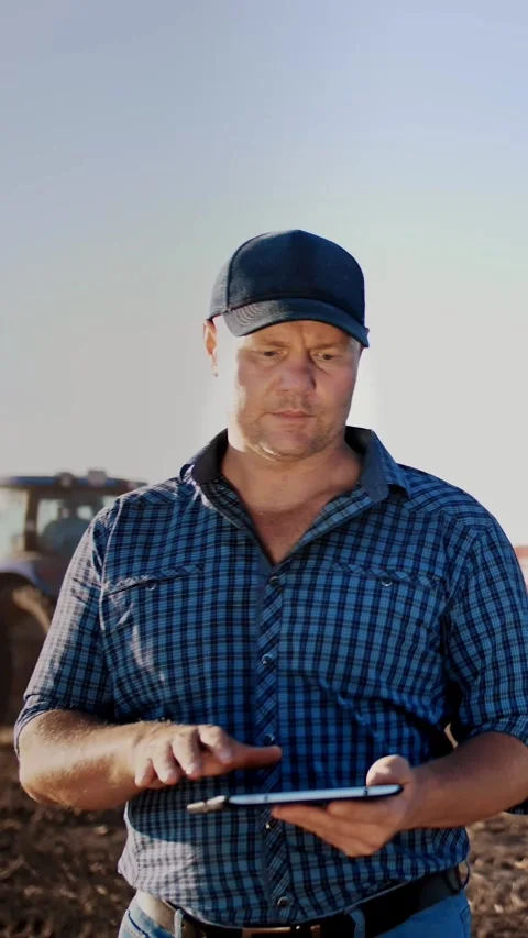 Potato harvesting. farmer using digital tablet. on farm field, on farm machinery Stock Footage 313484965