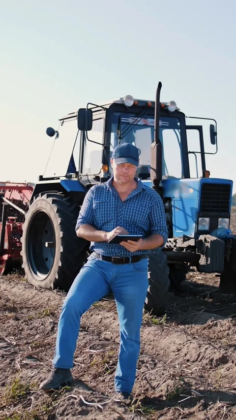 Potato harvesting. farmer using digital tablet. on farm field, on farm machinery Stock Footage 314236578