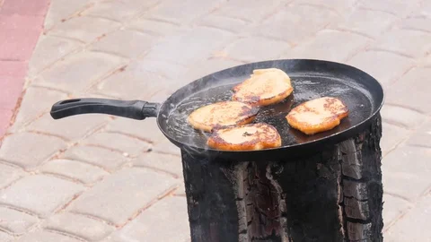 Potato pancakes, fried deep-fried in a pan over an open fire. Stock-Footage 100881423