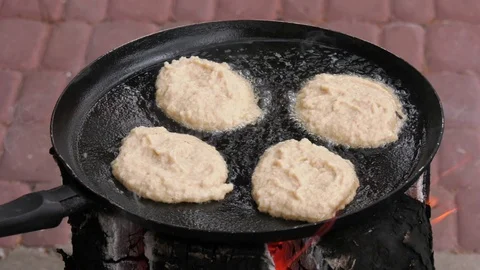 Potato pancakes, fried deep-fried in a pan over an open fire. Stock-Footage 100881432