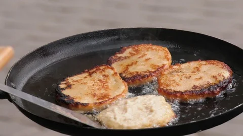 Potato pancakes, fried deep-fried in a pan over an open fire. Stock-Footage 100881457