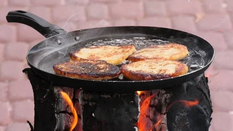 Potato pancakes, fried deep-fried in a pan over an open fire. Stock-Footage 100881470