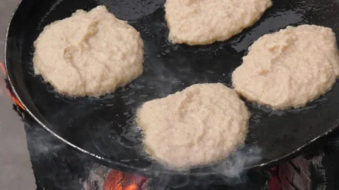 Potato pancakes, fried deep-fried in a pan over an open fire. Stock-Footage 100881489