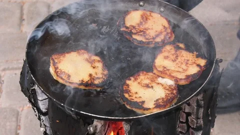 Potato pancakes, fried deep-fried in a pan over an open fire. Stock-Footage 100881540