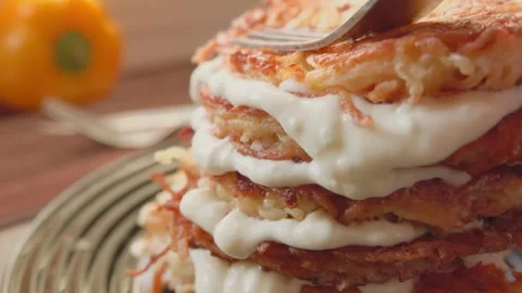 Potato pancakes stacked in layers over yogurt Stock Footage 308792848