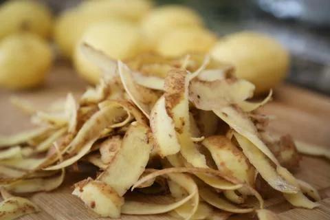 Potato peels, peeling a stack of potatoes with peels in foreground Stock Photos