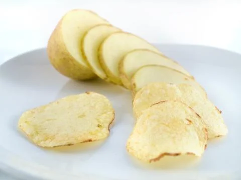 Potato sliced into chips crisps Stock Photos