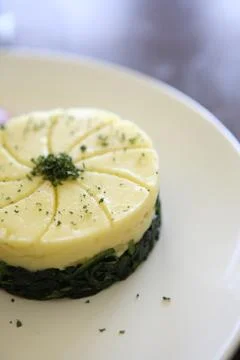 Potato on spinach Stock Photos