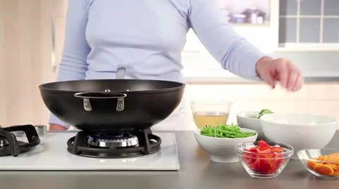 Potatoes and carrots being placed in a wok Stock Footage 24672659