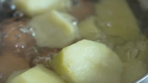 Potatoes and eggs boiling in a pot of bubbling water Stock Footage 333634166