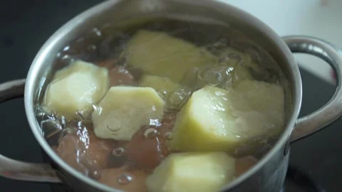 Potatoes and eggs boiling in a pot of bubbling water Stock Footage 333634264