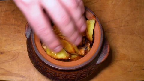 Potatoes and meat are placed in a ceramic pot, for stewing in the oven Stock Footage 248069157