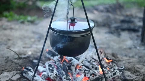 Potatoes are boiling in a pot over the fire. Cooking in the campaign Stock Footage 133553498