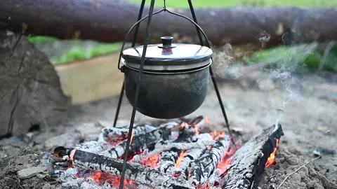 Potatoes are boiling in a pot over the fire. Cooking in the campaign Stock Footage 133554019