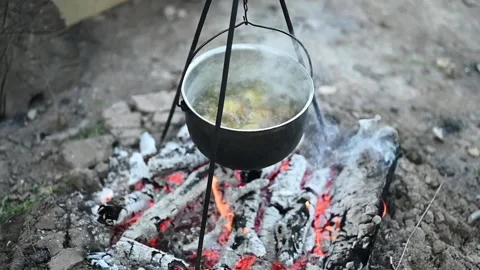 Potatoes are boiling in a pot over the fire. Cooking in the campaign Stock Footage 133554212