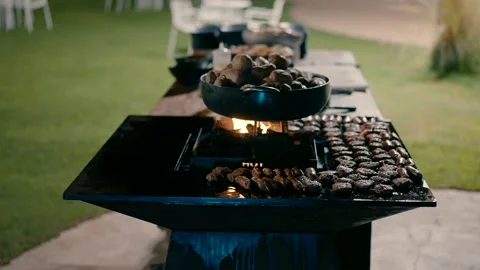 Potatoes are cooked in a frying pan on the fire in the outdoor kitchen. Video stock 231142257