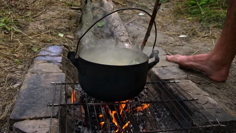 Potatoes are Cooked in a Large Cauldron Over an Open Fire During the Day Stockbeeldmateriaal 252202108