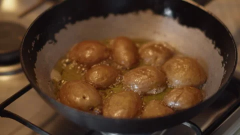 Potatoes are fried in melted butter in a pan 库存影片 337119098