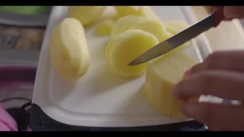Potatoes Being Cut With Knife on White Cutting Board Stock Footage 341444767