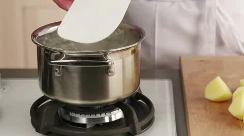 Potatoes being placed in a pot of boiling water Stock-Footage 24671474