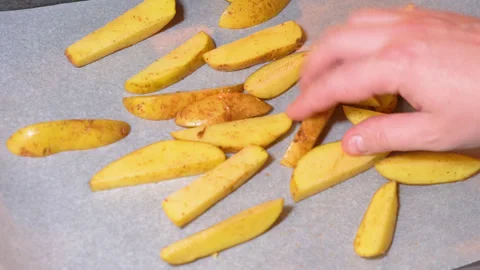 Potatoes being prepared for baking in the oven Stock Footage 250441387
