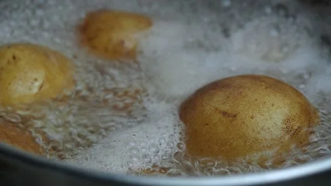 Potatoes in boiling water are cooked in an iron pot. Stock Footage 130494429