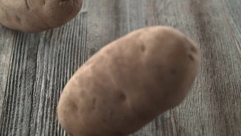 Potatoes falling and rolling on a table. Slow Motion. Stock Footage 84928885