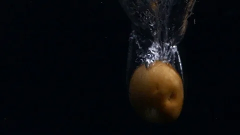 Potatoes falling in water on black background. 스톡 동영상 121783261