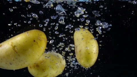 Potatoes falling into the water in slow motion. Vidéo 77226249