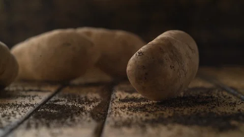 Potatoes falling on wooden table. Slow Motion. Stock Footage 89613146