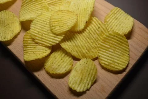 Potatoes fried wavy, embossed chips with sour cream and greens, facies Stock Photos