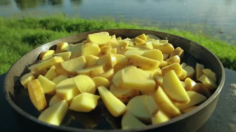 Potatoes in a frying pan. a man throws potatoes on a frying pan and frys it on a Stock Footage 136329828