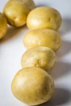 The potatoes lie in two rows on a white background. Stock Photos
