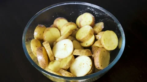 Potatoes marinated in baking spices are in a glass bowl. Stock Footage 233270438