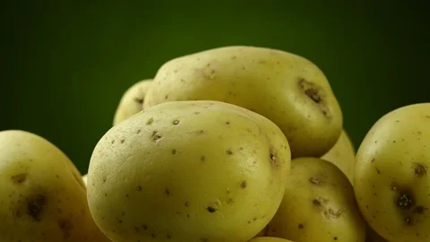 Potatoes rotating closeup on green background Stock Footage 126765089