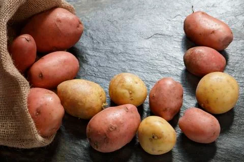 Potatoes on slate table Stock Photos