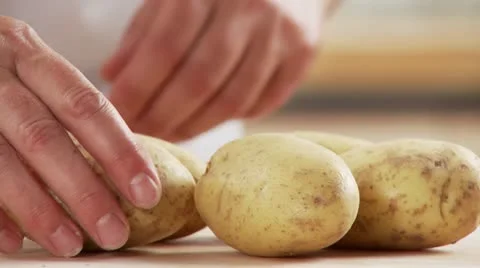 Potatoes in their skins being put in a pot Stock Footage 24642522