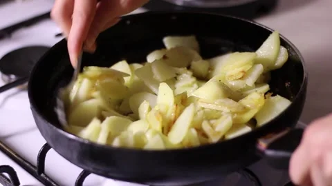 Potatoes, which are fried in a frying pan, are mixed with spoon. Vidéo 150236420
