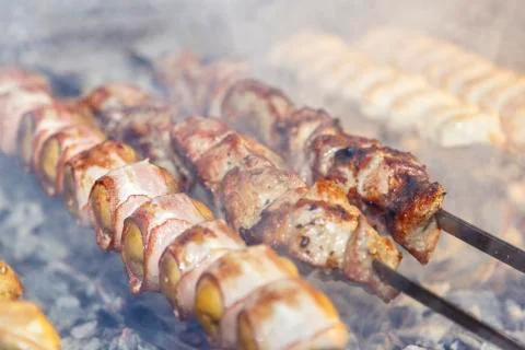 Potatoes wrapped in bacon, threaded on a skewer and roasted on the grill. Nex Stock Photos