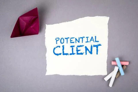 POTENTIAL CLIENT. Text on note sheet and paper boat on a gray background Stock Photos