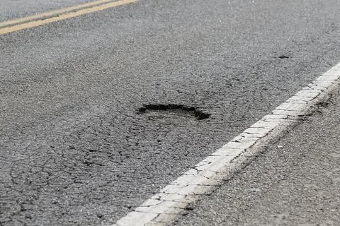Pothole on high speed highway representing accident risk and lack of mainte.. 스톡 사진