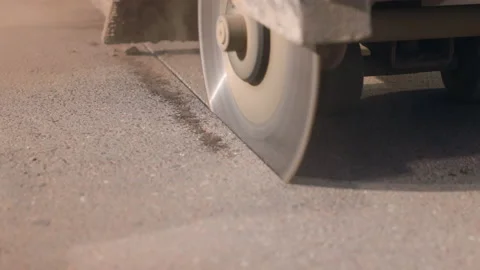 Pothole repair on a road. Close-up of a circular saw cutting out a section of Video stock 239332838