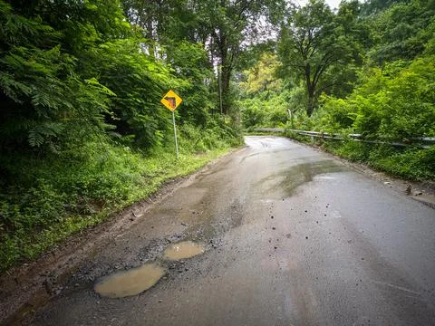Potholed asphalt road Stock Photos