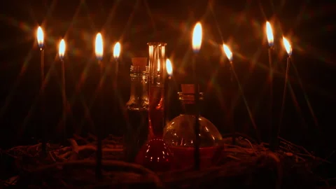 Potion vials surrounded with black magic candles and forest twigs on black .. Stock Footage 345451071