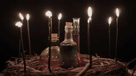 Potion vials surrounded with black magic candles and forest twigs on black .. Stock Footage 345451078