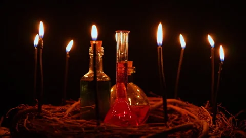 Potion vials surrounded with black magic candles and forest twigs on black .. Stock Footage 345451118