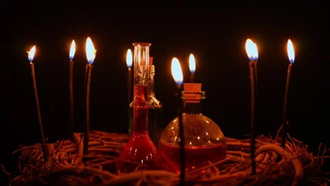 Potion vials surrounded with black magic candles and forest twigs on black .. Stock Footage 345456518
