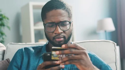 Potrait of attractive young african man with glasses using smart phone for Stock Footage 75725770