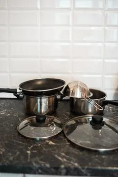 Pots and other kitchenware on a kitchentop. Clean kitchen concept. Stock Photos
